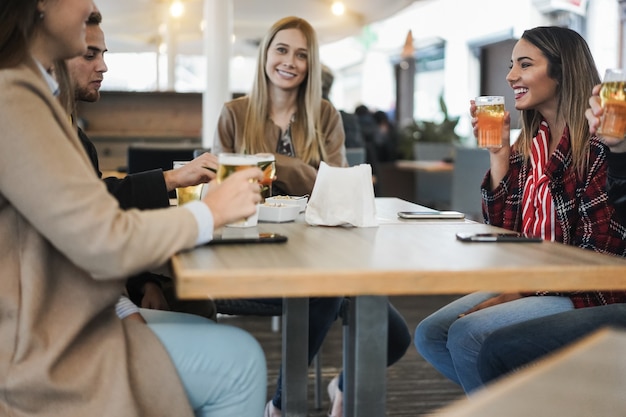 Junge Freunde, die zusammen Spaß haben, Bier im Bar-Restaurant zu trinken - Konzentrieren Sie sich auf das rechte Gesicht der Frau