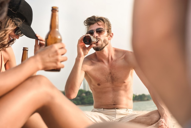 Junge Freunde genossen Getränke am Strand