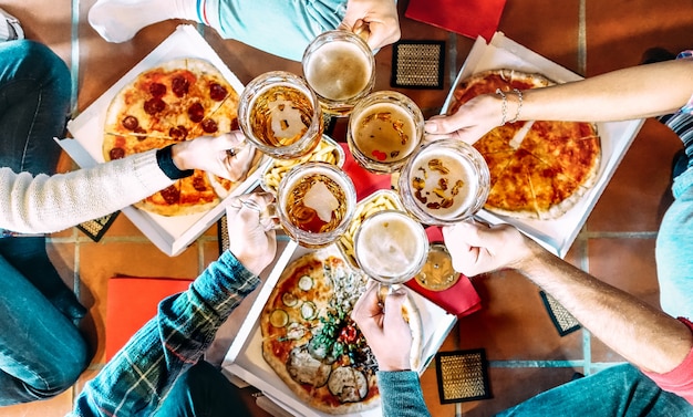 Junge Freunde Mitbewohner essen Pizza zu Hause nach dem College wegnehmen