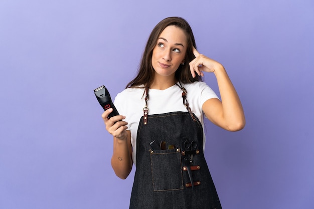 Junge Friseurfrau über isoliertem Hintergrund, der Zweifel und Denken hat