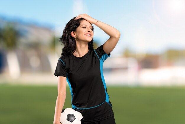 Junge Fußballspielerfrau hat etwas verwirklicht und die Lösung an im Freien beabsichtigt