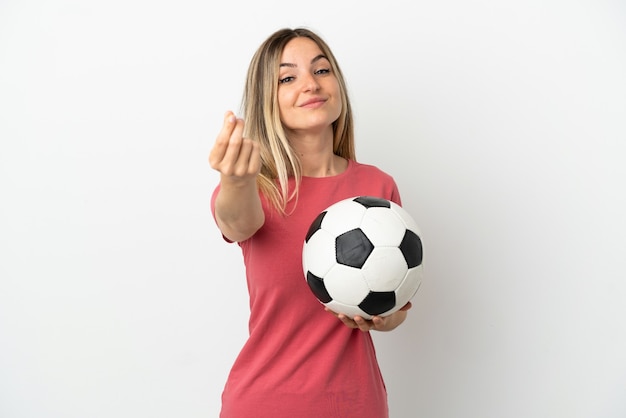 Junge Fußballspielerfrau über isolierter weißer Wand, die Geldgeste macht