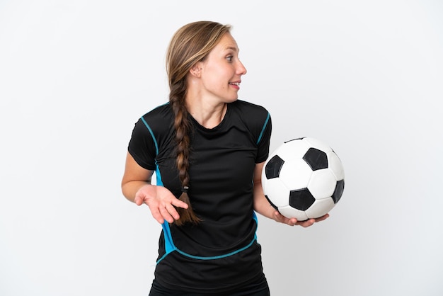 Junge Fußballspielerin isoliert auf weißem Hintergrund mit Überraschungsausdruck beim seitlichen Blick