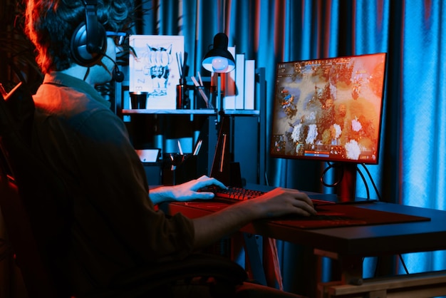 Junge Gaming-Streamer spielt Moba mit Kopfhörern und Mikrofon Gusher