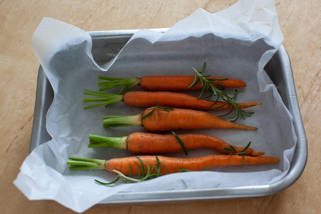 Junge ganze Karotte mit Gemüse im Backblech