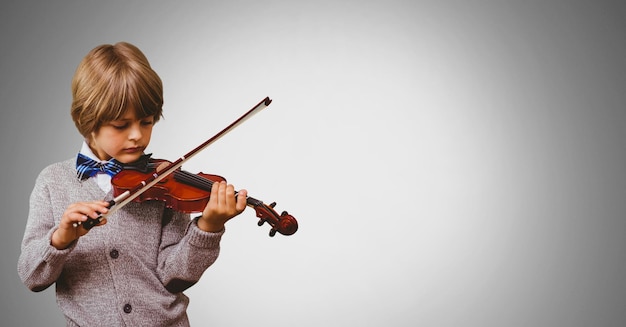 Junge gegen grauen Hintergrund, der Geige spielt