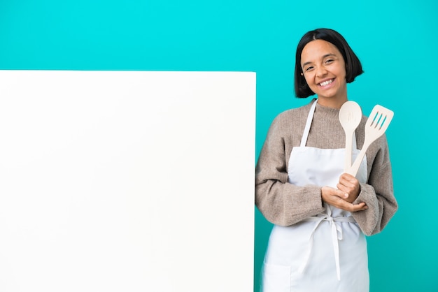 Junge gemischte Köchin Frau mit einem großen Plakat isoliert