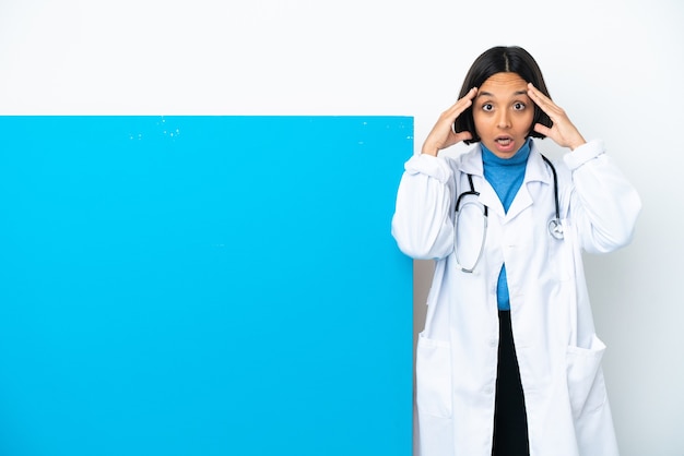 Junge gemischte Ärztin mit einem großen Plakat isoliert auf weißem Hintergrund mit Überraschungsausdruck