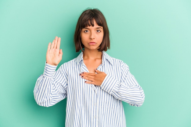 Junge gemischtrassige Frau einzeln auf blauem Hintergrund, die Ohren mit den Fingern bedeckt, gestresst und verzweifelt durch eine laute Umgebung.