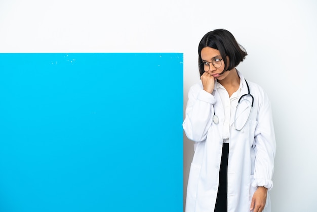 Junge gemischtrassige Ärztin mit einem großen Plakat isoliert auf weißem Hintergrund mit müdem und gelangweiltem Ausdruck