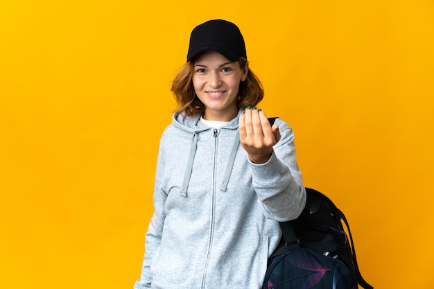 Junge georgische Sportfrau mit Sporttasche über isoliertem Hintergrund, die einlädt, mit der Hand zu kommen. Schön, dass du gekommen bist