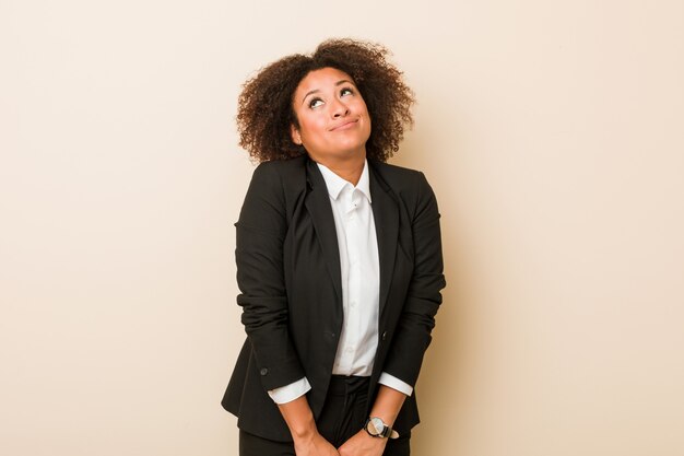 Junge Geschäfts-Afroamerikanerfrau, die davon träumt, Ziele und Zwecke zu erreichen