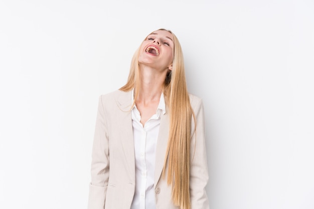 Junge Geschäftsblondine auf weißer Wand entspannten sich und das glückliche Lachen, der ausgedehnte Hals, der Zähne zeigt.