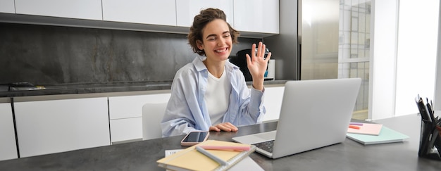 Foto junge geschäftsfrau benutzt einen laptop, während sie im büro steht