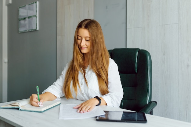 Junge Geschäftsfrau, die am Arbeitsplatz im Büro sitzt