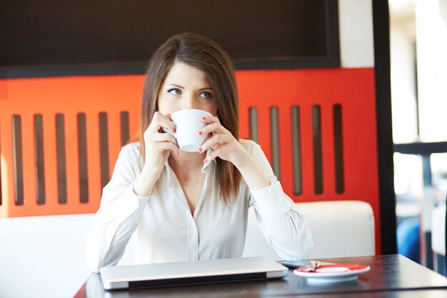 Junge Geschäftsfrau, die am Café arbeitet