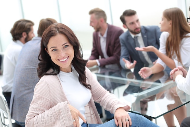 Junge Geschäftsfrau, die bei Corporate Business Team Meeting sitzt