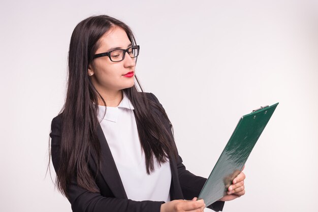 Junge Geschäftsfrau, die Brille trägt, Papierordner auf Weiß hält