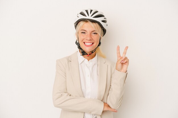 Junge Geschäftsfrau, die Fahrradhelm lokalisiert auf weißem Hintergrund hält, der Nummer zwei mit den Fingern zeigt.