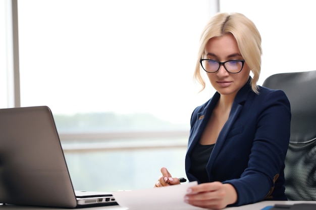 Junge Geschäftsfrau, die im Büro arbeitet