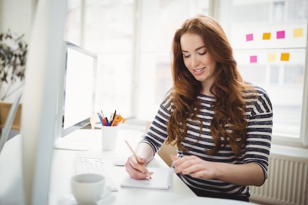 Junge Geschäftsfrau, die im kreativen Büro arbeitet