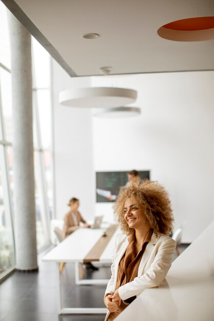 Junge Geschäftsfrau, die im modernen Büro steht