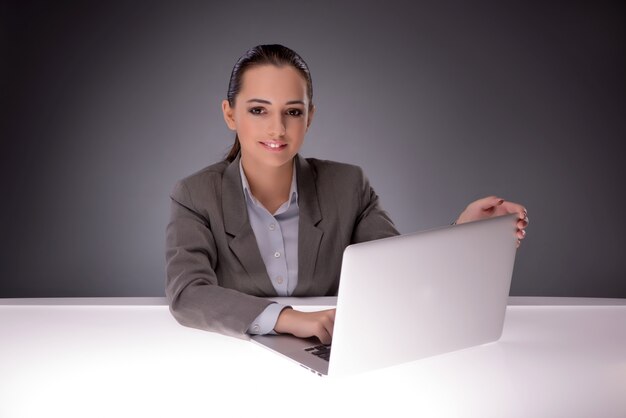 Junge Geschäftsfrau, die mit Laptop im Geschäftskonzept arbeitet
