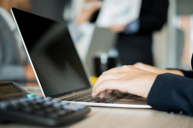 junge Geschäftsfrau, die mit Laptop und Dokumentenin Büro arbeitet