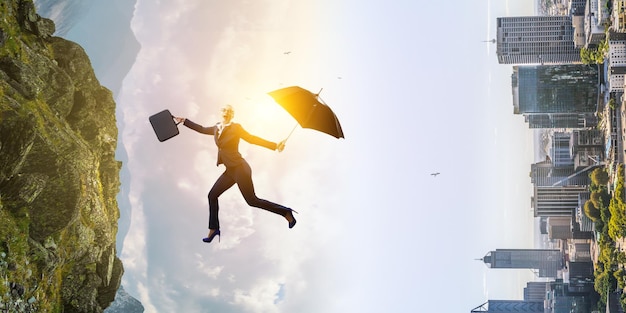 Junge Geschäftsfrau, die mit Regenschirm geht. Gemischte Medien