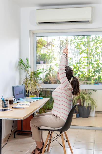 Junge Geschäftsfrau, die sich im Büro ausdehnt Fitness am Arbeitsplatz