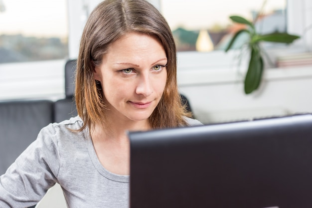 junge Geschäftsfrau hinter dem Laptop