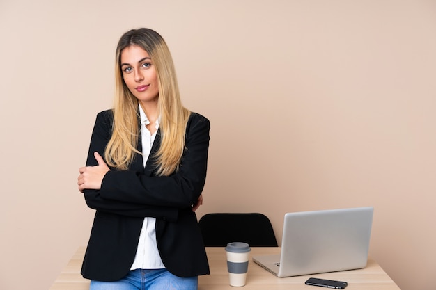 Junge Geschäftsfrau in einem Büro, das Arme verschränkt hält