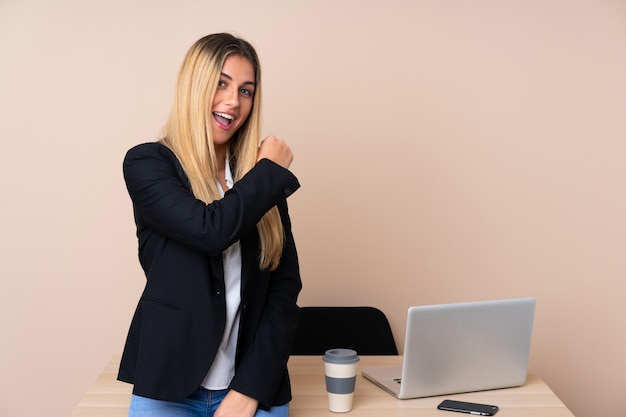 Junge Geschäftsfrau in einem Büro, das einen Sieg feiert