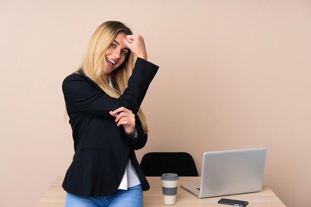 Junge Geschäftsfrau in einem Büro, das starke Geste macht