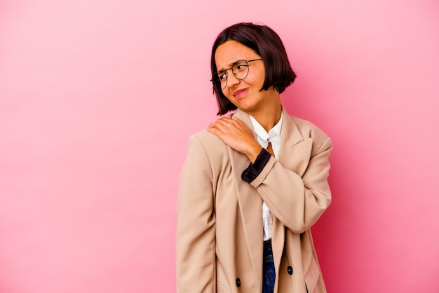 Junge Geschäftsfrau lokalisiert auf rosa Wand, die einen Schulterschmerz hat