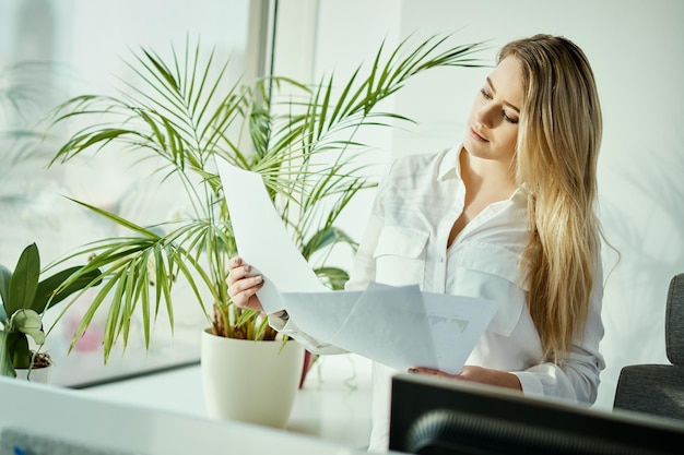 Foto junge geschäftsfrau mit dokumenten im büro