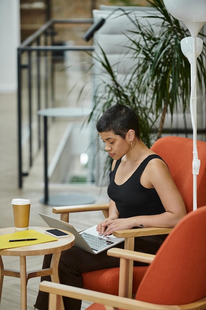 Foto junge geschäftsfrau mit laptop-coworking-startup-kultur gen z smartphone kaffee zum mitnehmen