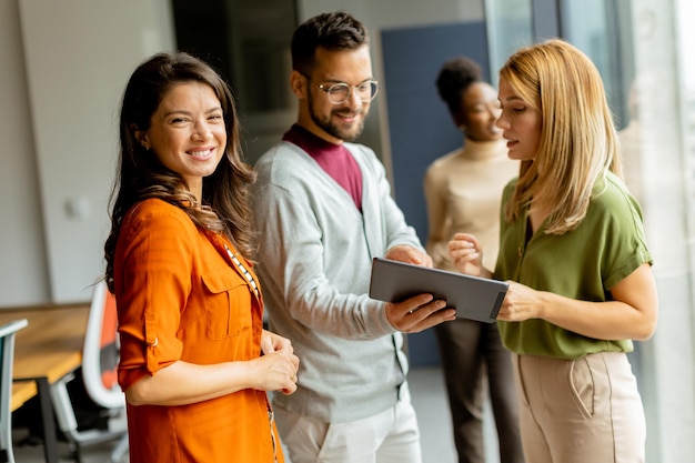 Junge Geschäftsfrau steht vor ihrem Team im modernen Büro