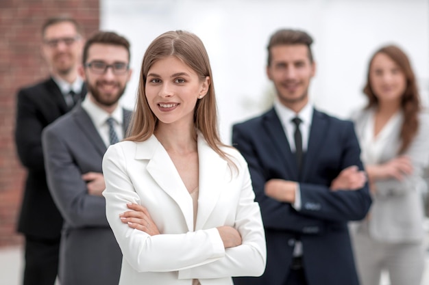 Junge Geschäftsfrau vor dem Hintergrund ihres Geschäftsteams das Konzept der Teamarbeit