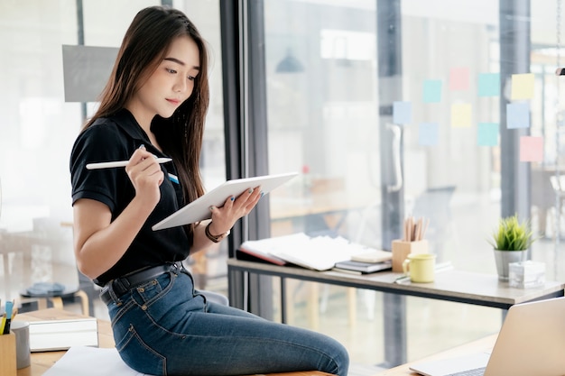 Junge Geschäftsfrau, welche die Tablette online sucht Informationsmarketing verwendet.