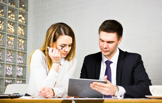 Junge Geschäftskollegen diskutieren über die Arbeit an einem Laptop im Co-Working-Space, Geschäftsleute aus Unternehmen