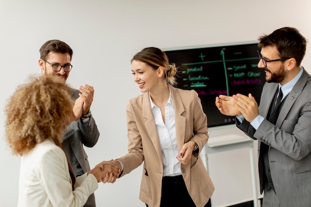 Junge Geschäftsleute, die am Besprechungstisch im Konferenzraum sitzen und Arbeit und Planungsstrategie diskutieren