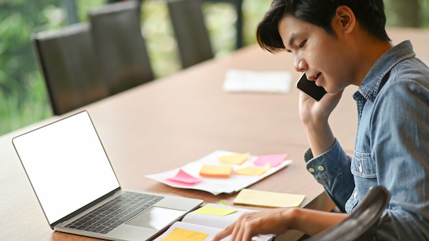 Junge Geschäftsleute rufen an, um zu arbeiten und Laptop zu benutzen.