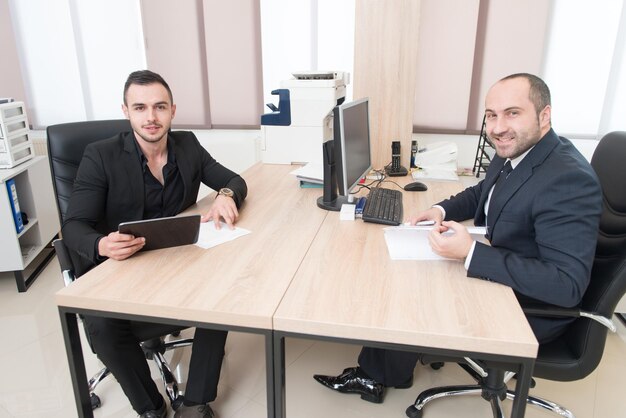 Junge Geschäftsleute treffen sich und arbeiten in einem modernen, hellen Büro im Innenbereich