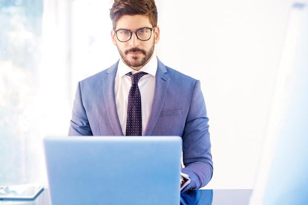 Junge Geschäftsperson, die hinter Notizbuch im Büro sitzt