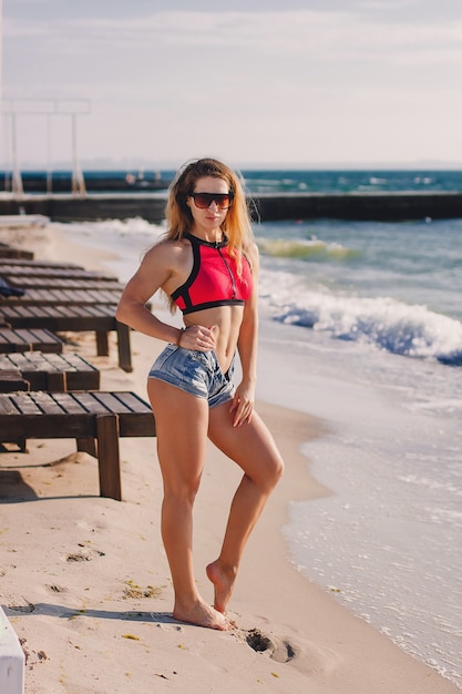 Junge gesunde Lifestyle-Sport-Fitness-Instruktor glückliche Frau im Bikini am Strand.