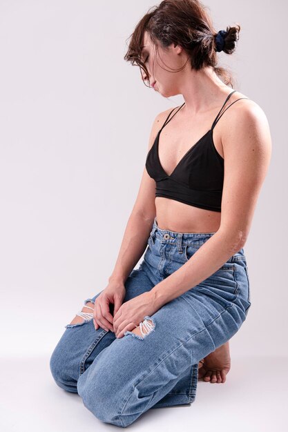 Junge gesunde schöne Frau in sportlichem Top und Leggings, die zu Hause Yoga praktiziert