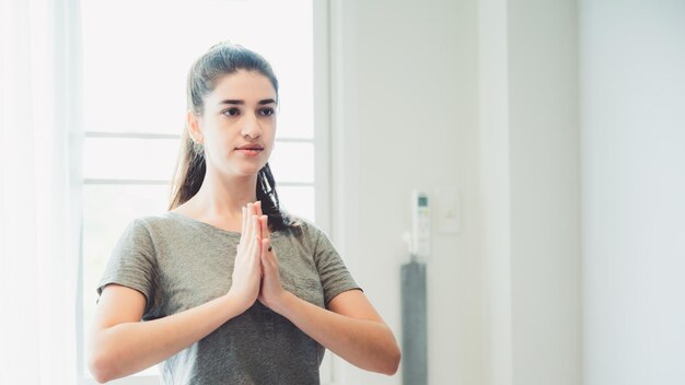 Junge Gesundheitsfrau, die Videos anschaut, um Yoga zu Hause zu lernen, Fitnessübungen und sportlichen weiblichen Lebensstil, Körpertraining im Zimmerboden, Körperentspannung mit Online-Yoga