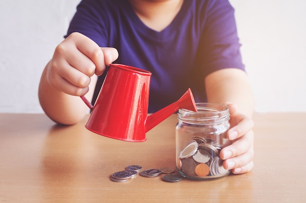 Junge gießt Münzen. Plan für Geld Konzept