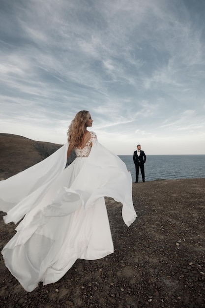 Junge glückliche Braut im Hochzeitskleid und -bräutigam